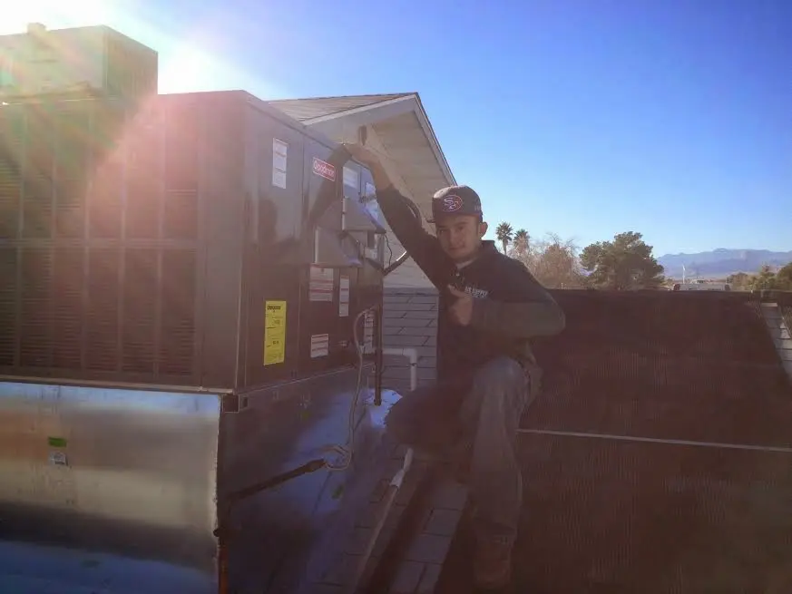 HVAC technician performing Air Duct Repair on a rooftop unit in Hartsville-Trousdale County