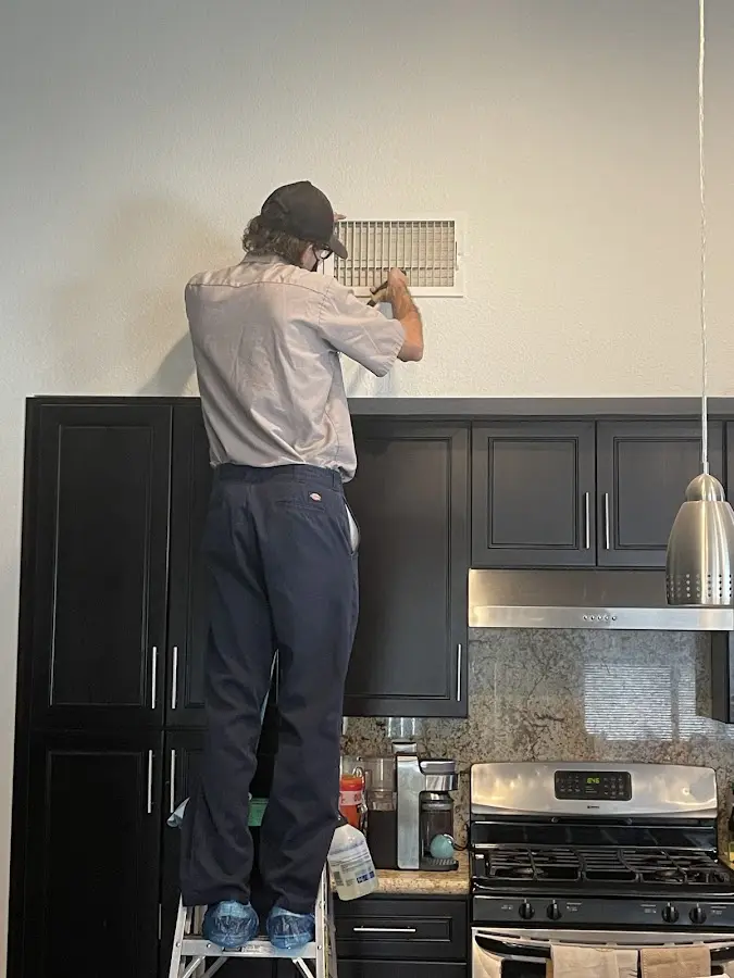 Technician inspecting an air vent during HVAC service in Hartsville-Trousdale County